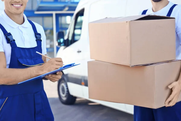 Two men moving boxes with a moving company